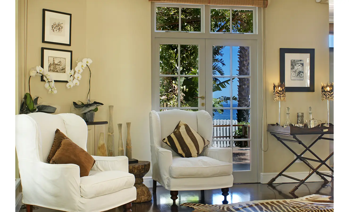 Perfect Hideaways: A cosy and inviting lounge with woven textures, plush seating, and warm lighting, creating a relaxed atmosphere for laid-back evenings by the sea. Dolphin Cottage, Camps Bay.