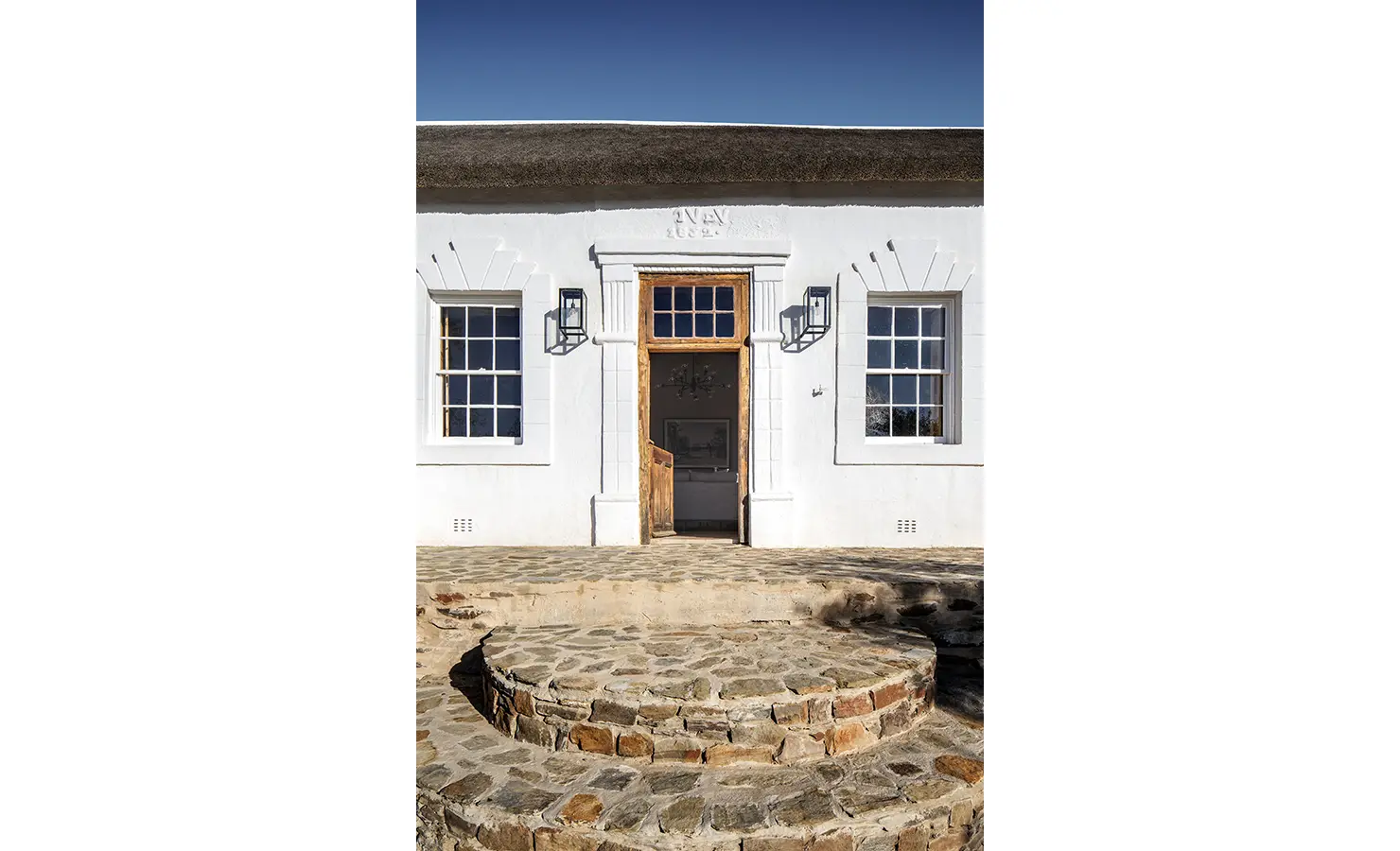 Perfect Hideaways: Cape Dutch façade with thatched roof, sash windows and circular stone steps to a stable door, Ladismith, Buffelsdrift