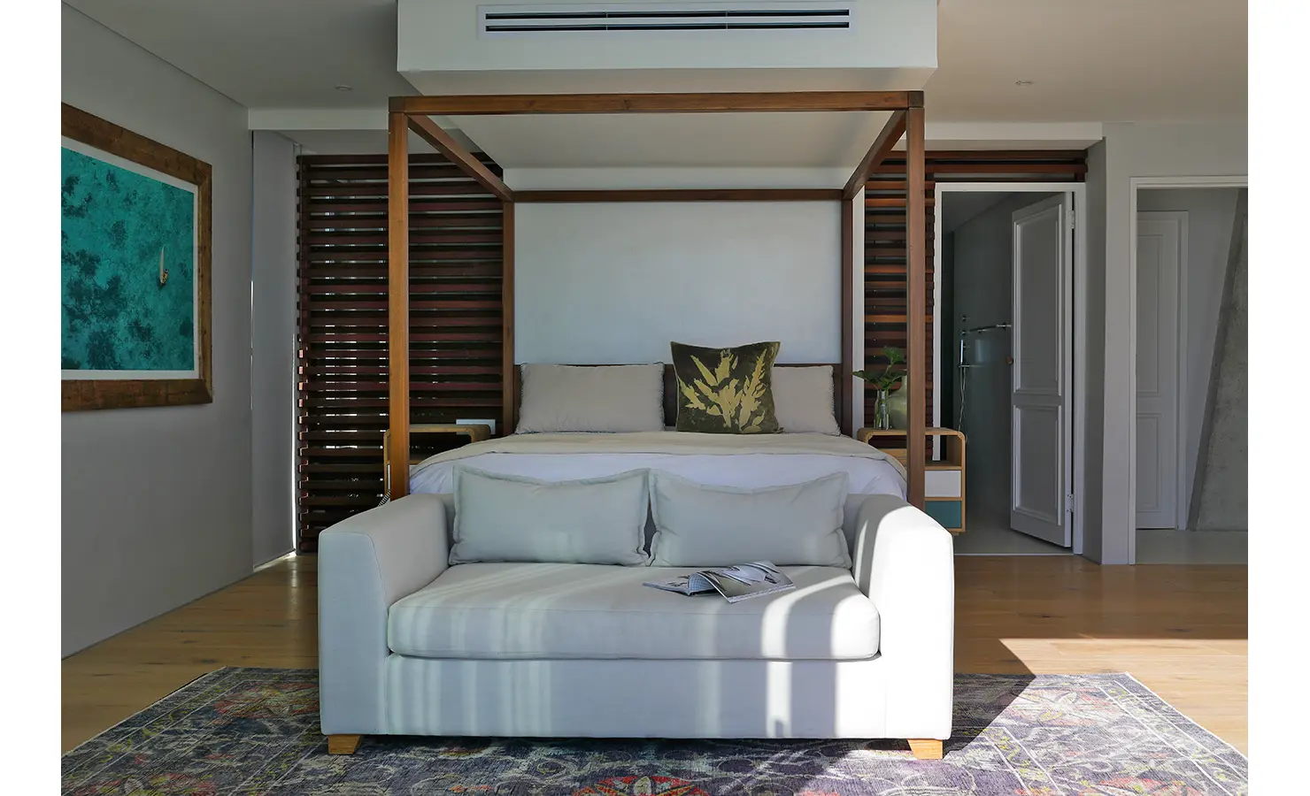 Perfect Hideaways: A dreamy bedroom opens directly onto a pool deck with a spectacular sea view, where calm tones and soft textures enhance the tranquil seaside escape. Bahari, Llandudno.