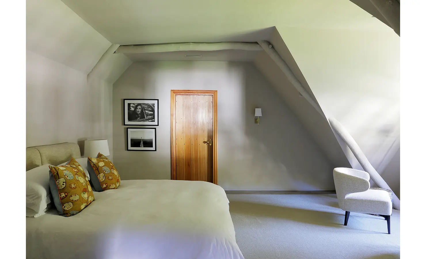 Perfect Hideaways: A cosy attic bedroom with sloped ceilings, neutral tones, and minimalist furnishings, creating a peaceful retreat. Owloon, Paarl.