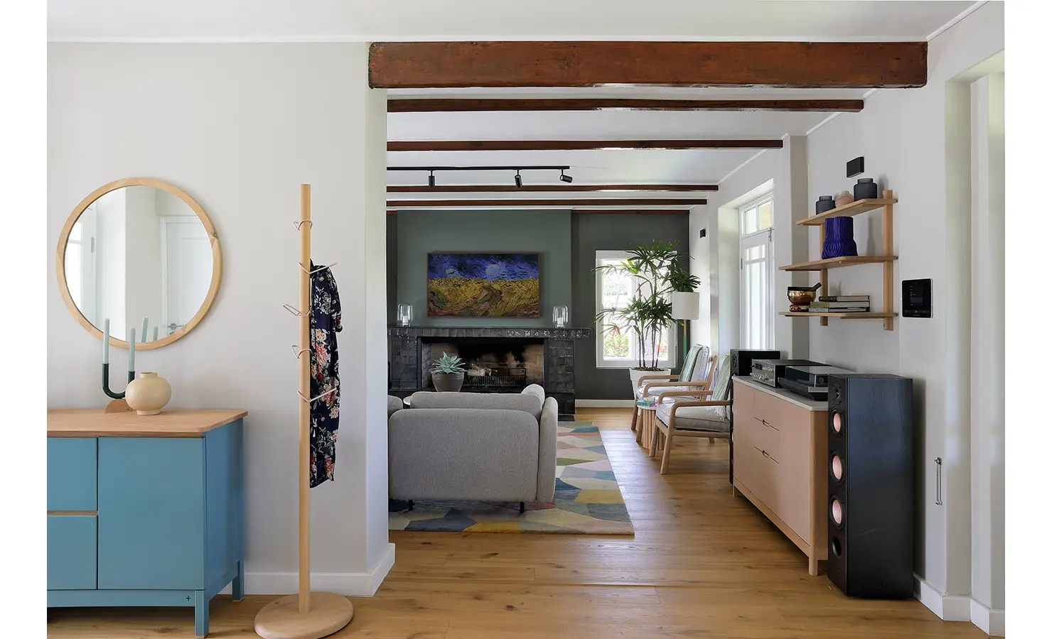Perfect Hideaways: A stylish interior view showcasing a living area with exposed wooden beams, colourful décor, and a mirror above a side table. Stillwater Sanctuary, Hemel-en-Aarde.