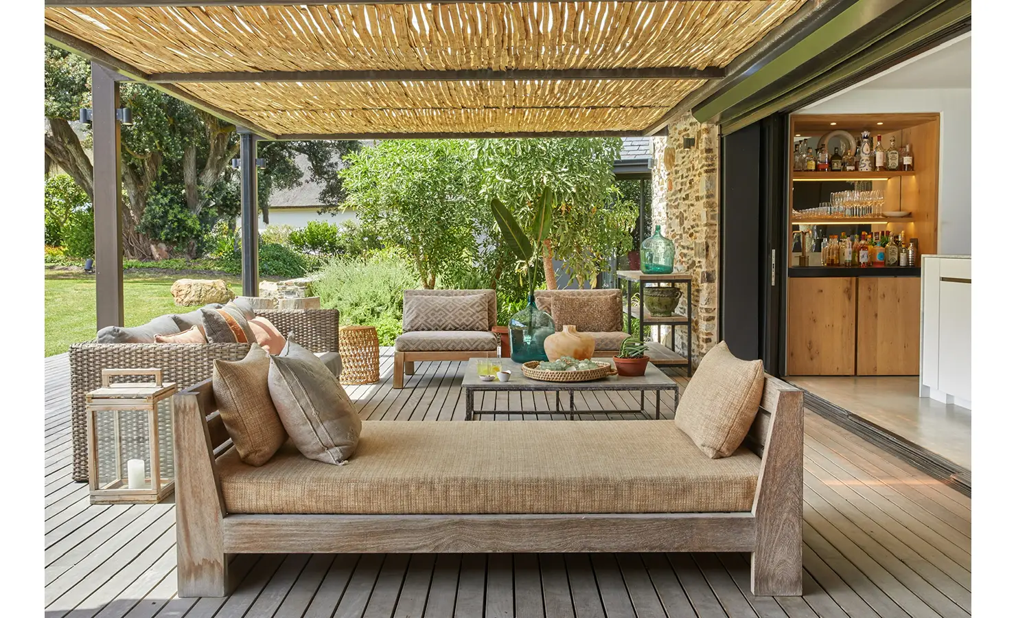 Covered outdoor deck area with reed ceiling and neutral toned occasional furniture. Cliffside. Hermanus.