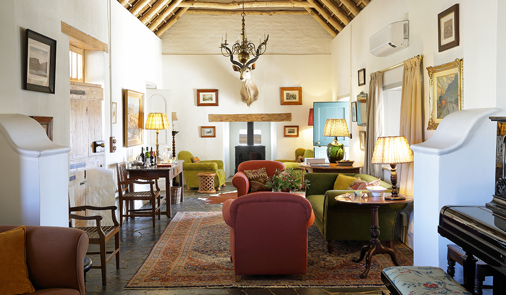 Living room with open beams and fireplace. Perfect Hideaways, De Kruis, Tankwa Karoo, Northern Cape, South Africa. Photo: Henrique Wilding