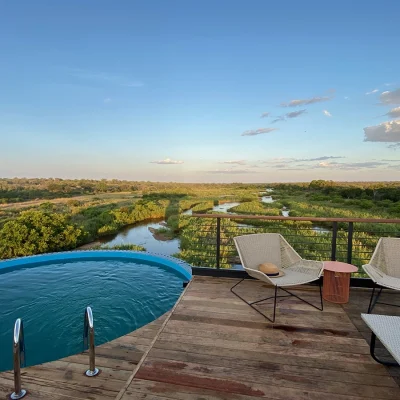 Elevated deck with a plunge pool and two reclining chairs overlooking the magnificent plains and meandering river.