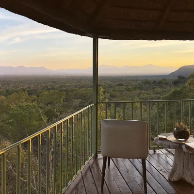 Evening on Manor House's tall lookout deck with expansive views of the bush and mountain ranges.