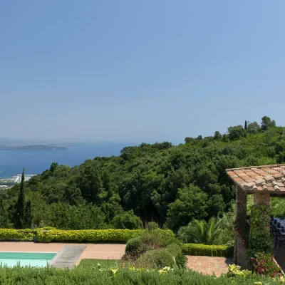 Villa Sunshine's pool area that lies adjacent to an outdoor seating area protected by a terracotta roof with views of the forested slopes of Tuscany and the bustling yacht marina.