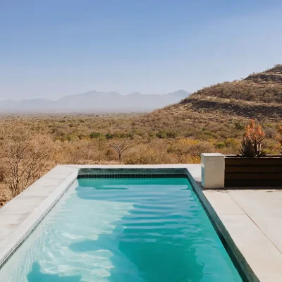 Lengthy swimming pool on The Blogck deck overlooking the Limpopo bushveld and distant Waterberg mountains.