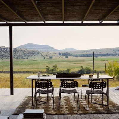 Sleek granite dining table protected by the pergola on the Herenberg patio and facing the vast grassy plains of the Freestate.