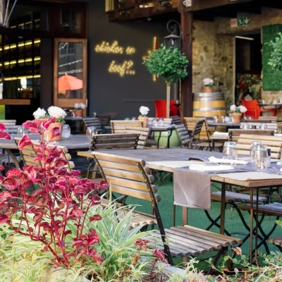 Outdoor courtyard at the Cape Heritage Hotel furnished with wooden tables and chairs.