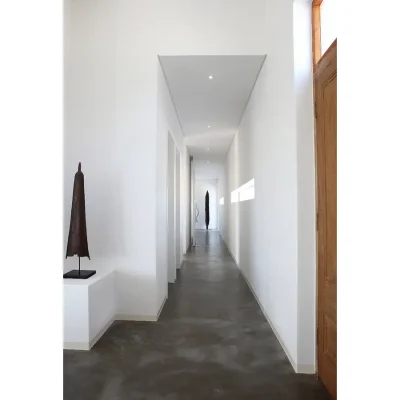 Minimalistic whitewashed passage with natural light and epoxy floors.