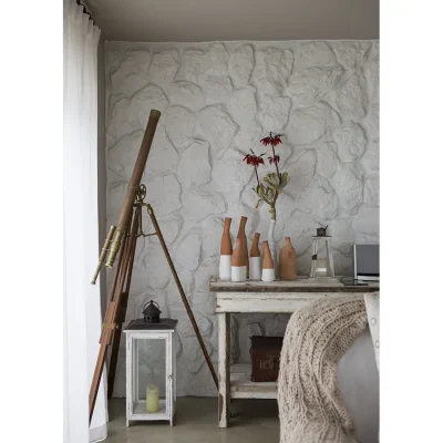 Whitewashed stone wall matching a white cabinet with decorative ornaments and a statement antique telescope.