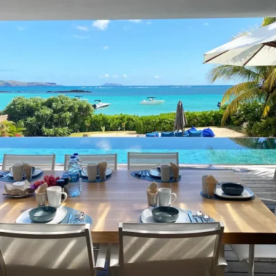 Outdoor dining table overlooking an infinity pool, secluded garden and ocean views.