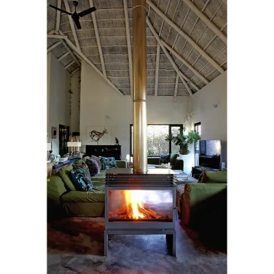 Freestanding cast iron fireplace central to Manor House lounge surrounded by soft, green sofas and African inspired artwork.