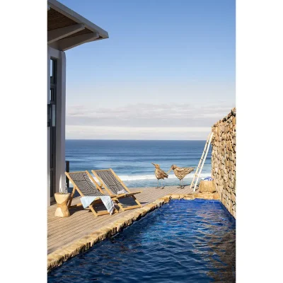 Deck with a plunge pool and two striped sun loungers overlooking the blue ocean. Lekkerwater Beach Lodge.