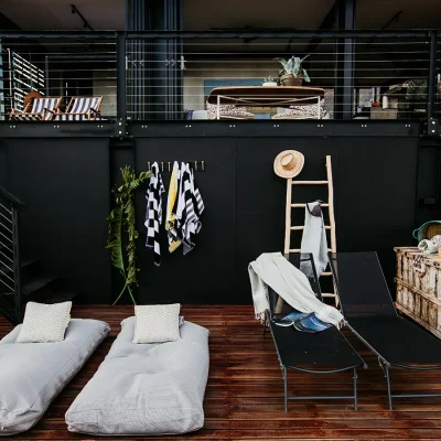 Lower wooden deck at the View with soft loungers set against a charcoal black wall.