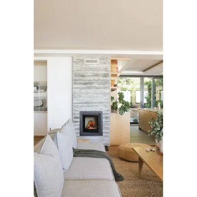 Oasis on glen living room with a soft grey sofa complimenting the stone wall with a built in fire place. Oasis On Glen.