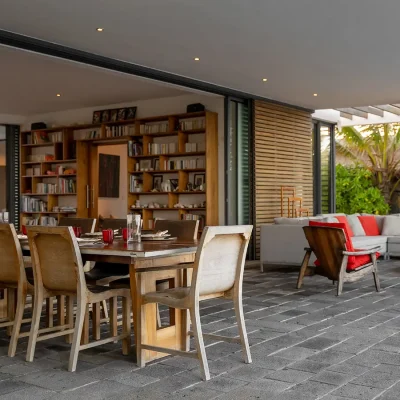 Stack doors opening up the villa to protected outdoor dining table and chairs.