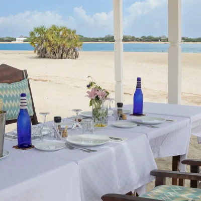 Dining on the deserted beach, seated on plush wooden chairs and overlooking the ocean. The Fort.