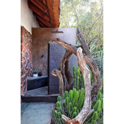 Outdoor garden shower enclosed by natural brown sandstone walls. Manor house.