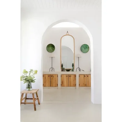 Buchubos Villa with large white arches that exposes a built in cabinet and large mirror.