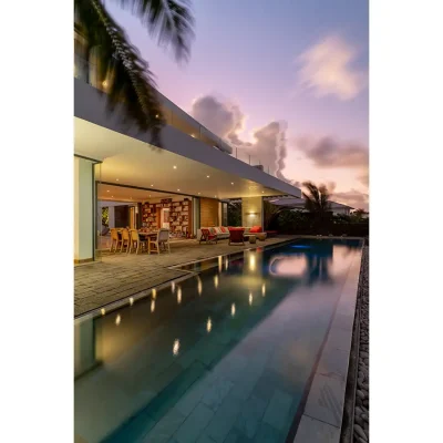 Villa with an outdoor infinity pool and a pink hue sky.