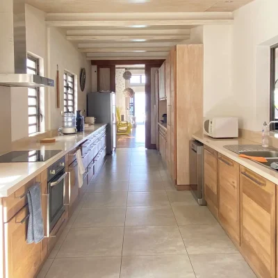 Spacious modern kitchen with sleek wooden cabinets and plentiful storage space.