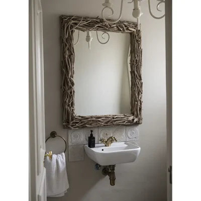 Ceramic washbasin with decorative framed mirror mounted against a beige wall in Beach House Zonnestraal bathroom.