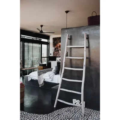 Spacious bedroom suite in the Blogck with charcoal walls that match the built in bed base with crisp white sheets and decorative pillows facing large stack back glass doors.