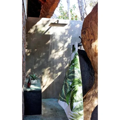 Outdoor shower enclosed by natural brown sandstone walls. Manor house.