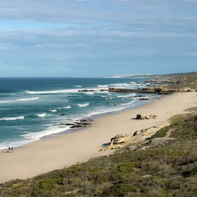 People walking on extended coastline of De Hoop nature reserve.