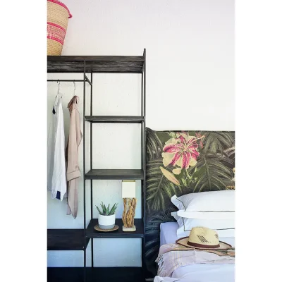 White crisp linen and tropical headboard positioned alongside an open plan cupboard in Manor House bedroom suite.