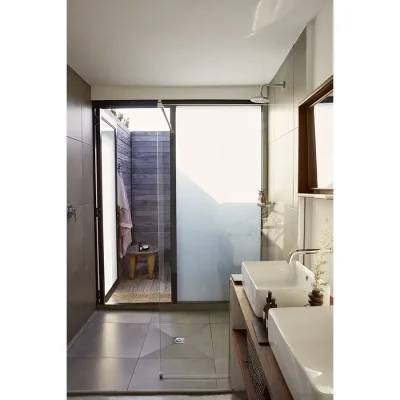 The Herenberg's main ensuite with ceramic twin washbasins and a stained glass door leading to an outdoor shower.