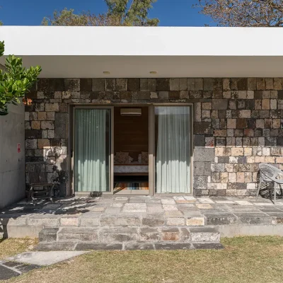 Secluded cottage on Villa De L'Ocean property with outdoor stone tiled verandah and stone walls.