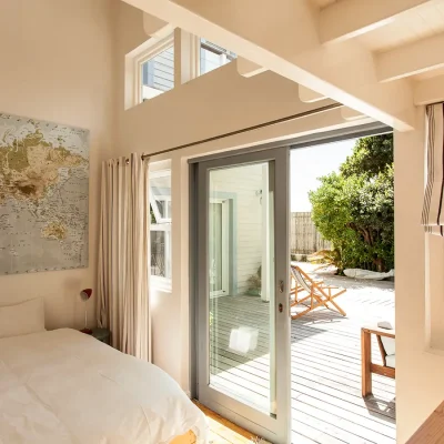 Pebbles bedroom with a flood of natural light from the glass sliding doors that open onto the wooden deck.