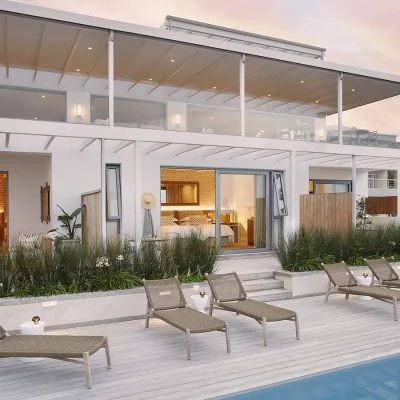 The face of Walkers Beach Villa with whitewashed walls, and multiple bedroom suites that open via large glass sliding doors that face the large deck and swimming pool.