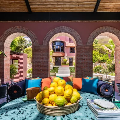 Indoor outdoor sitting area with large arches and large fruit bowl of lemons. House Nouveau.