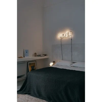 Casa Piana bedroom with white washed walls that compliments the white bed linen and warmed by the charcoal knitted throw and artwork on the floating shelf.