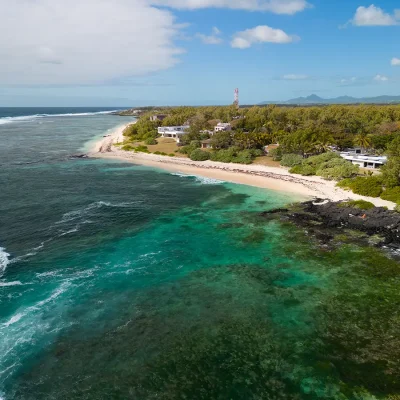 Serene and turquoise coral reef situated on the east coast with luscious green forests and scattered coastal properties. Villa De L'Ocean.