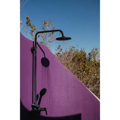 Outdoor shower at the Blogck with a bright pink wall.