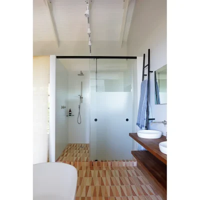 Frosted glass shower with decorative, orange floor tiles and twin washbasins. Pinebeach bathroom.