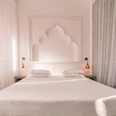 The Fort bedroom suite with white, crisp hues reflecting in the walls, bed linen and curtains.