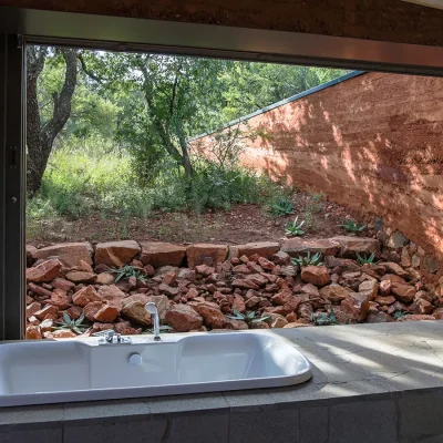 Large bay window with built in bath tub overlooking the wild garden at Witklipfontein eco lodge.