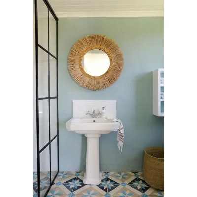 Bathroom with blue walls and a white ceramic washbasin and glass shower.