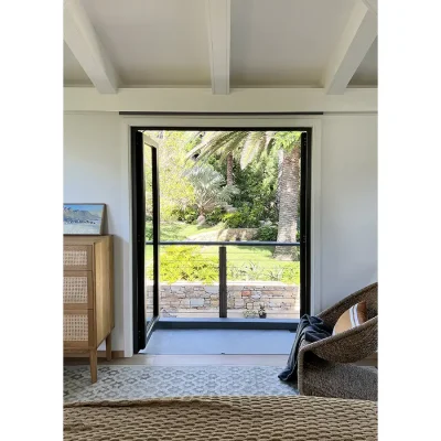 Bedroom suite with a large rug, a corner wicker chair and double glass doors that open onto a patio overlooking Oasis On glen garden.