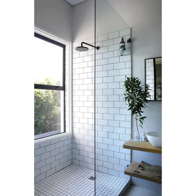 White tiled shower with window and glass enclosure in Pinebeach bathroom.