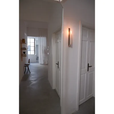 Casa Piana bedroom hallway with epoxy flooring and white walls with detailed white wooden doors.