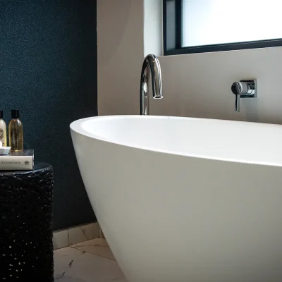 En suite bathroom with blue navy wall with free standing white bath tub in Labotessa Hotel.