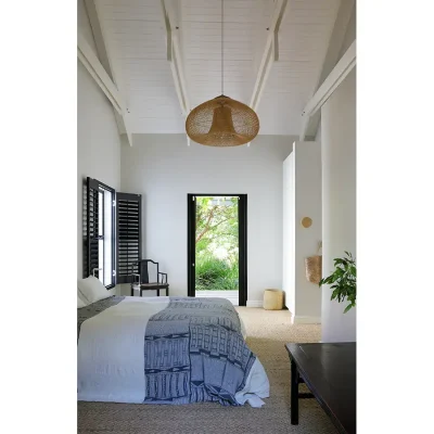 Contemporary bedroom with whitewashed walls that compliment the fresh white linen on the double bed decorated with a charcoal throw that compliments the black window shutters. Pinebeach.