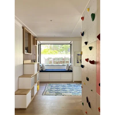 Children's bedroom in Oasis On Glen with a built in bunk bed, a reading nook and a climbing wall.