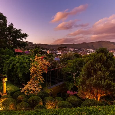 Sculpture garden with large trees, hedges and city views. House Nouveau.